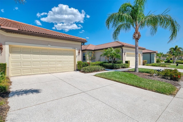 view of front of home with a garage, stucco siding, concrete driveway, and a tiled roof