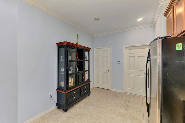 interior space featuring freestanding refrigerator, ornamental molding, light tile patterned flooring, baseboards, and recessed lighting