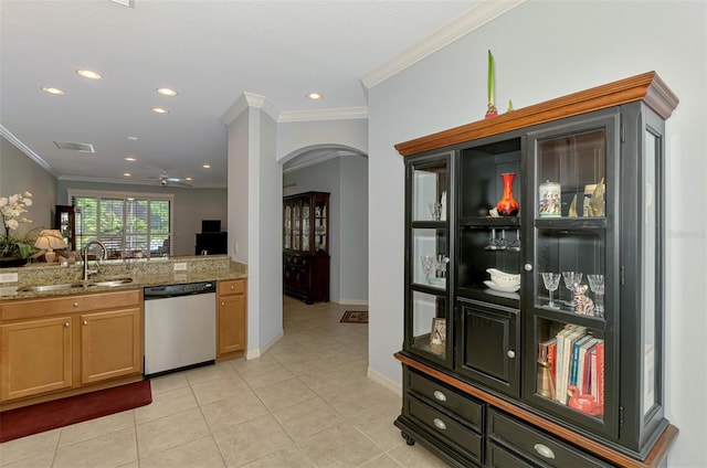 kitchen with a sink, arched walkways, crown molding, and dishwasher