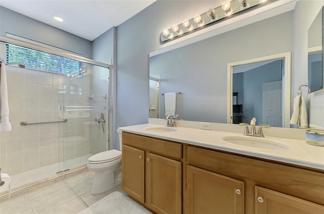 bathroom with a sink, tile patterned floors, a stall shower, and toilet