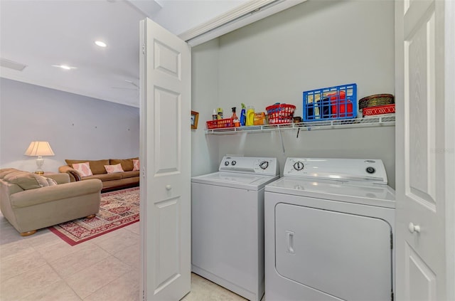 clothes washing area featuring washer and dryer, laundry area, and light tile patterned floors