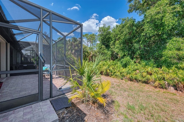 view of yard with a patio and glass enclosure
