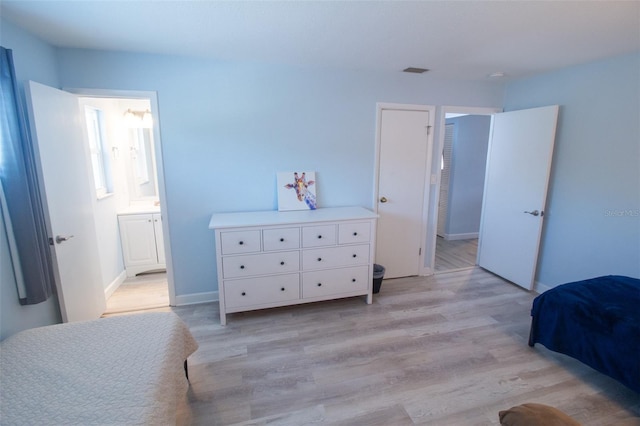 400 Base Unit 225, Venice, FL 34293 - bedroom featuring light wood-style floors, baseboards, and ensuite bathroom
