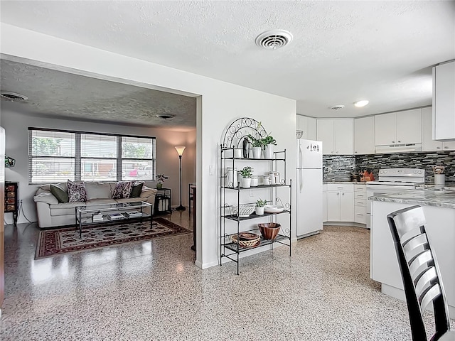 2108 Lee Ln, Sarasota, FL 34231 - kitchen featuring white appliances, under cabinet range hood, a textured ceiling, white cabinetry, and decorative backsplash