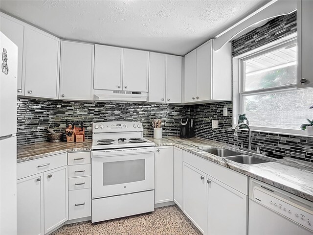 2108 Lee Ln, Sarasota, FL 34231 - kitchen with white appliances, under cabinet range hood, a sink, a textured ceiling, and dark aggregate flooring