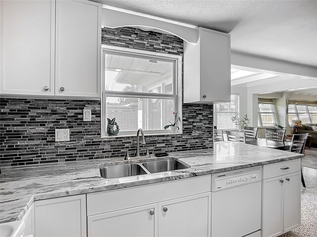 2108 Lee Ln, Sarasota, FL 34231 - kitchen featuring white dishwasher, a sink, white cabinetry, and tasteful backsplash