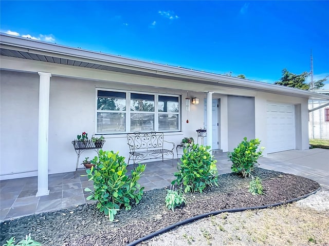 2108 Lee Ln, Sarasota, FL 34231 - view of front of property with covered porch, stucco siding, driveway, and a garage