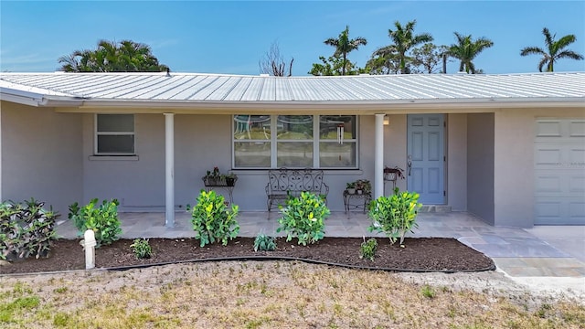 2108 Lee Ln, Sarasota, FL 34231 - view of exterior entry with covered porch, stucco siding, and metal roof