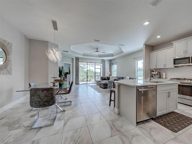 220 Sarezzo Cir, Nokomis, FL 34275 - kitchen with stainless steel appliances, a sink, open floor plan, a center island with sink, and light marble finish flooring