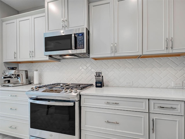 220 Sarezzo Cir, Nokomis, FL 34275 - kitchen featuring appliances with stainless steel finishes, decorative backsplash, and white cabinets