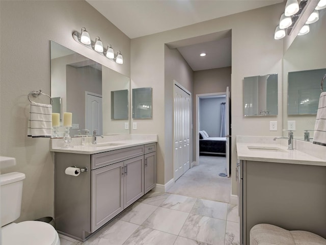 220 Sarezzo Cir, Nokomis, FL 34275 - full bath featuring toilet, two vanities, marble look tiles, and baseboards