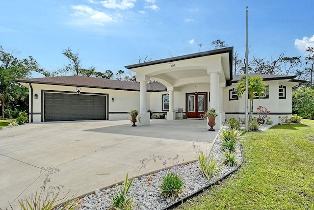 66 Statler St, Port Charlotte, FL 33954 - view of front of home with an attached garage, driveway, french doors, and stucco siding