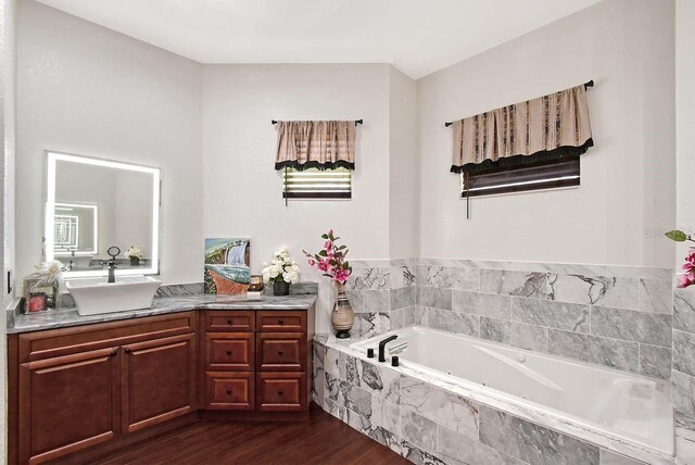 66 Statler St, Port Charlotte, FL 33954 - full bathroom featuring vanity, a garden tub, and wood finished floors