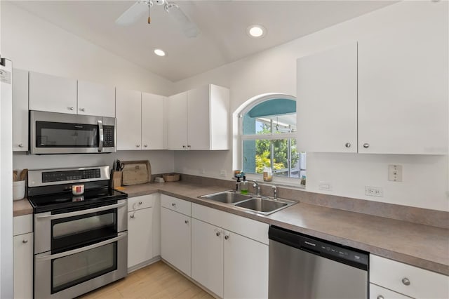5264 Albion Rd, Venice, FL 34293 - kitchen with lofted ceiling, white cabinets, a sink, stainless steel appliances, and a ceiling fan