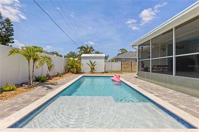 5264 Albion Rd, Venice, FL 34293 - view of swimming pool featuring an outdoor structure, a fenced in pool, a shed, a fenced backyard, and a sunroom