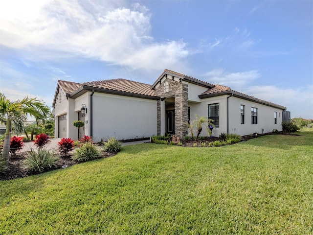 mediterranean / spanish-style house with a front yard, stucco siding, a tile roof, and an attached garage
