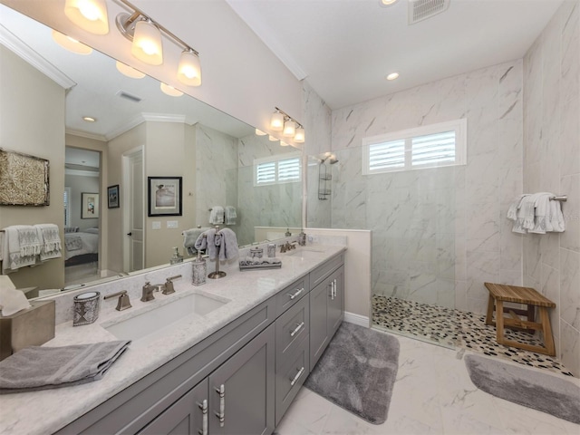 ensuite bathroom with a sink, visible vents, ensuite bathroom, ornamental molding, and marble finish floor