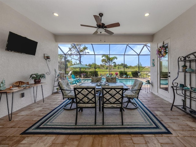 view of patio with outdoor dining space, an outdoor pool, a ceiling fan, and a lanai