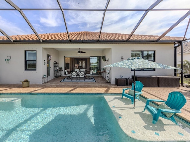 rear view of property with stucco siding, a hot tub, and a patio area