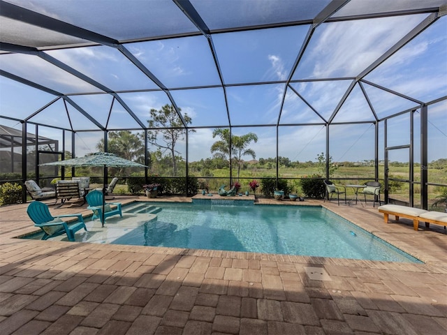 pool with glass enclosure and a patio area