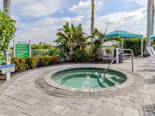 view of pool with a patio, fence, and a hot tub