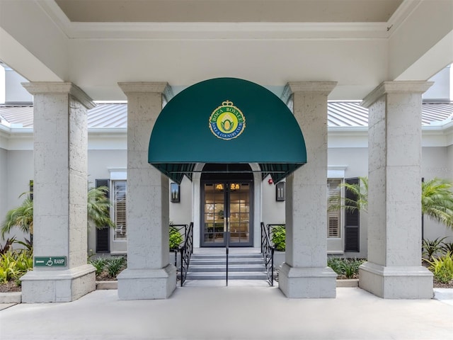view of exterior entry with stucco siding and french doors