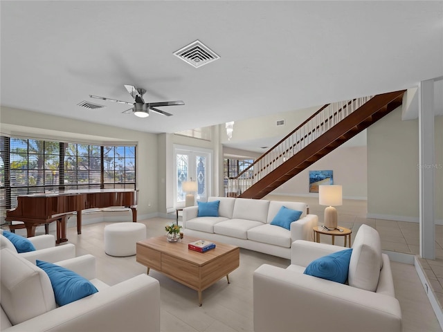 living room with light tile patterned flooring, a ceiling fan, and visible vents