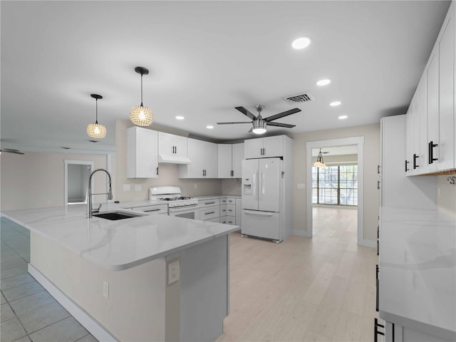 kitchen with a sink, ceiling fan, recessed lighting, white appliances, and a peninsula