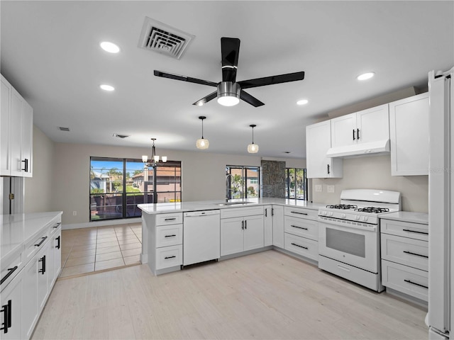 kitchen featuring a sink, under cabinet range hood, visible vents, white appliances, and ceiling fan with notable chandelier