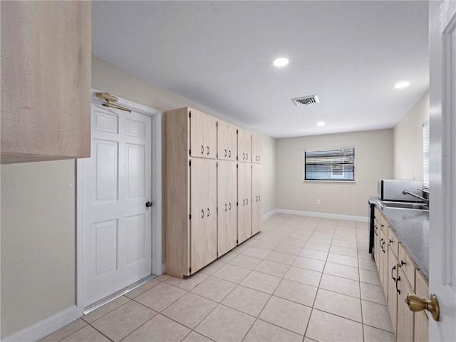 kitchen featuring recessed lighting, a sink, light tile patterned floors, visible vents, and baseboards