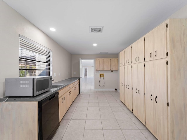 kitchen featuring light brown cabinets, stainless steel microwave, light tile patterned floors, black dishwasher, and visible vents