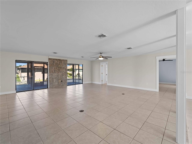 empty room featuring a ceiling fan, visible vents, and baseboards
