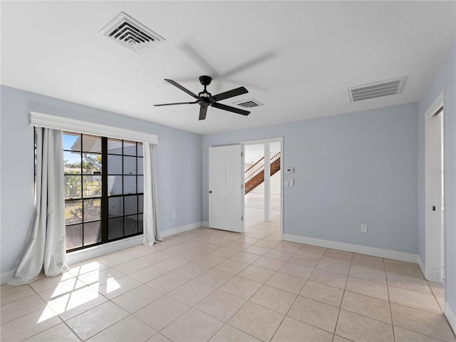 unfurnished room with a ceiling fan, visible vents, and baseboards
