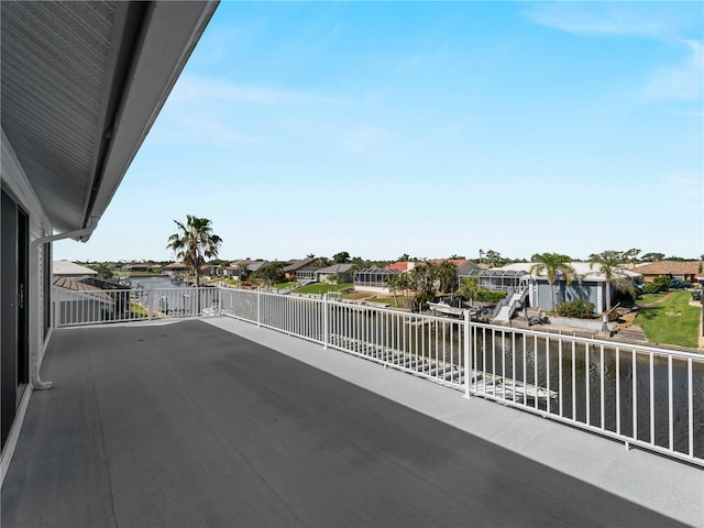 view of patio / terrace with a water view, a residential view, and a balcony