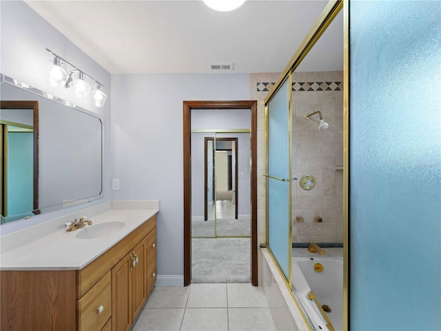 full bathroom with bath / shower combo with glass door, visible vents, baseboards, vanity, and tile patterned flooring