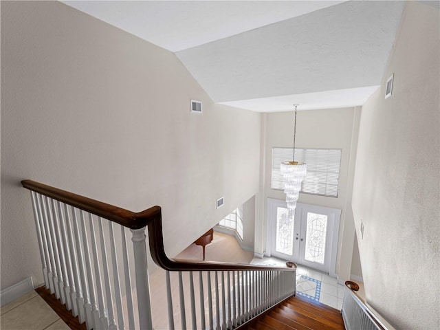 stairs with visible vents, a chandelier, french doors, and tile patterned floors