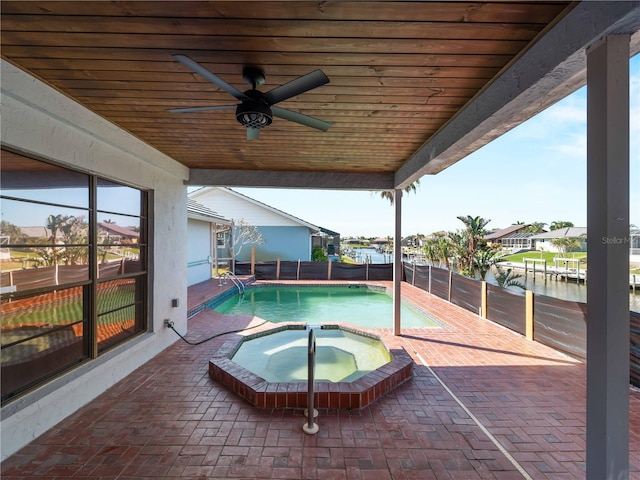 view of swimming pool with a patio, an in ground hot tub, a water view, ceiling fan, and a fenced backyard