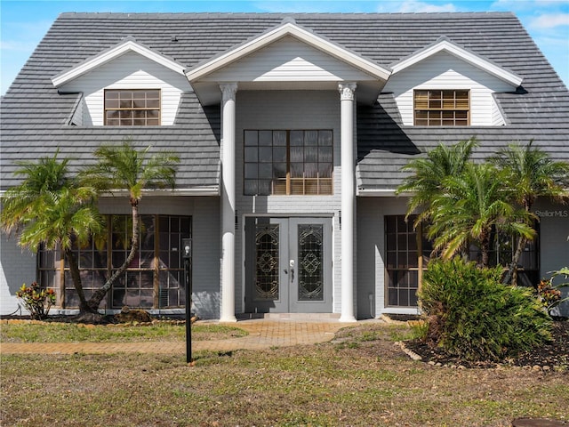 view of front facade with french doors and a front lawn