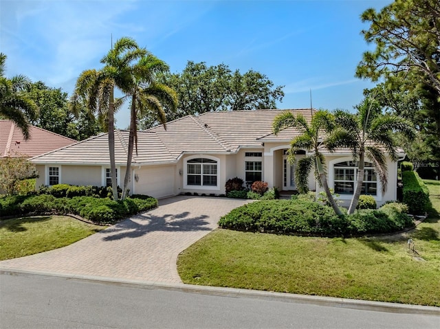 2022 Calusa Lakes Blvd, Nokomis, FL 34275 - single story home with a tile roof, decorative driveway, stucco siding, a front lawn, and a garage