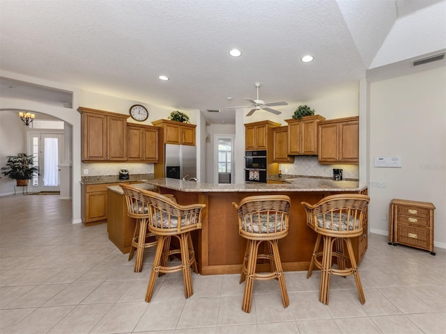 2022 Calusa Lakes Blvd, Nokomis, FL 34275 - kitchen featuring visible vents, tasteful backsplash, stainless steel fridge with ice dispenser, and brown cabinets
