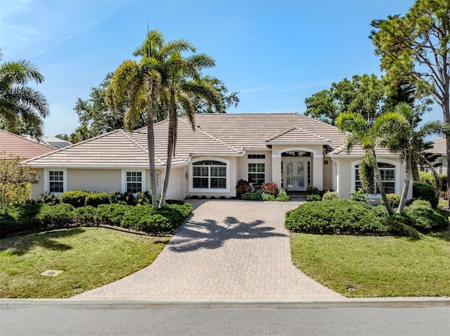 2022 Calusa Lakes Blvd, Nokomis, FL 34275 - ranch-style house with a front lawn, a garage, decorative driveway, stucco siding, and french doors