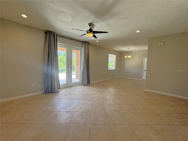 unfurnished room with light tile patterned floors, ceiling fan with notable chandelier, and a textured ceiling