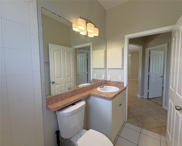 bathroom with vanity, toilet, a notable chandelier, and tile patterned flooring
