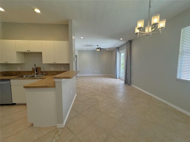 kitchen featuring recessed lighting, stainless steel dishwasher, light tile patterned floors, ceiling fan with notable chandelier, and a sink