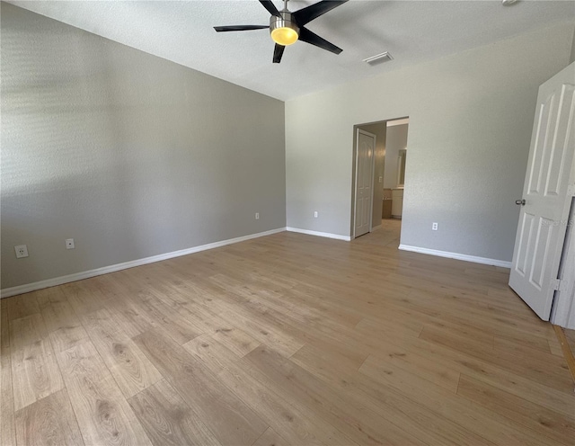 unfurnished bedroom featuring lofted ceiling, visible vents, baseboards, light wood-type flooring, and a ceiling fan