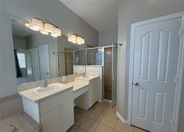 full bathroom with double vanity, a sink, a shower stall, and tile patterned floors