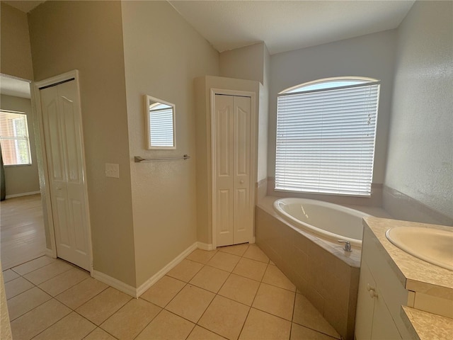 full bath featuring tile patterned flooring, a bath, and a closet