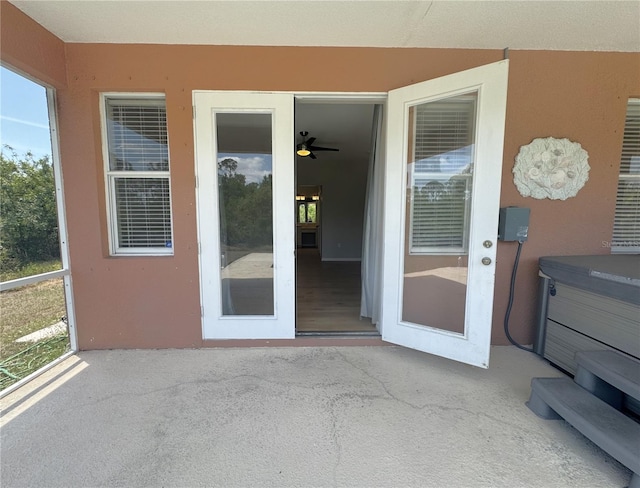 view of exterior entry with a patio and stucco siding