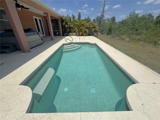 outdoor pool with a ceiling fan, french doors, and a patio area
