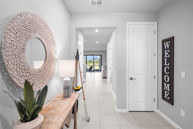 hall with light tile patterned flooring, visible vents, recessed lighting, and baseboards